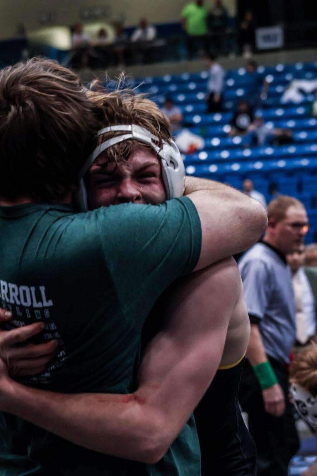 Bishop Carroll senior Brady Duling hugs his wrestling coach after becoming a state champion.