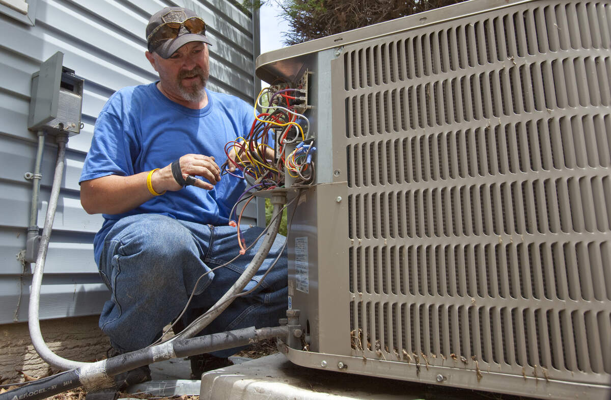 Jerry Cline of Total Heating and Cooling works on a air conditioner unit in 2011.