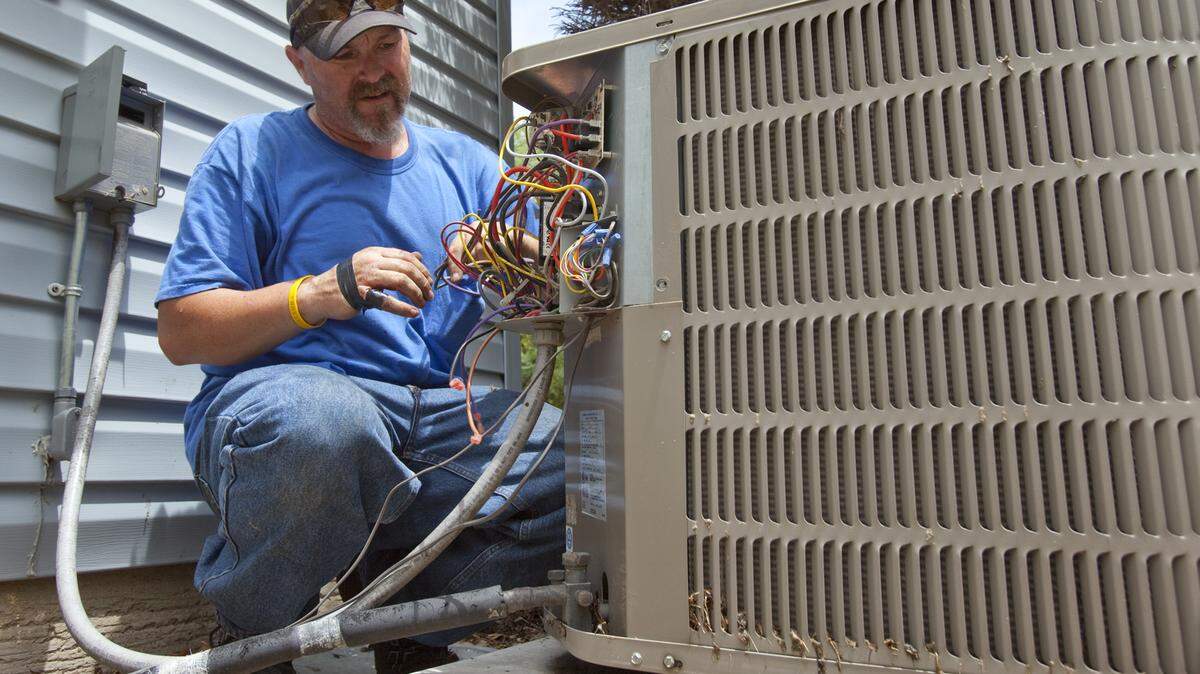 Jerry Cline of Total Heating and Cooling works on an air conditioner unit in this file photo.