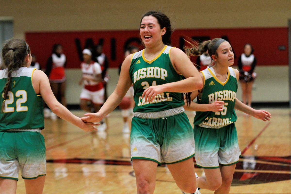 Bishop Carroll’s Britney Ho gives teammate Allison McFarren a high-five during the Golden Eagles’ 45-35 loss to Wichita Heights on Tuesday night. (Jan. 8, 2019)