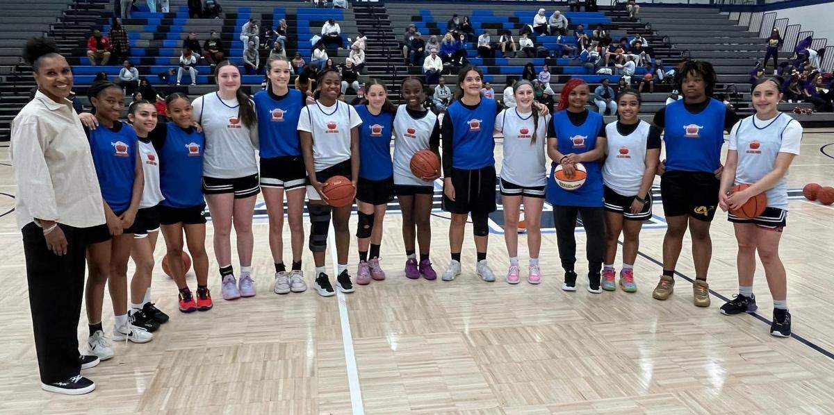Lynette Woodard poses with girls basketball players selected to participate in the middle school all-star game she helped create.