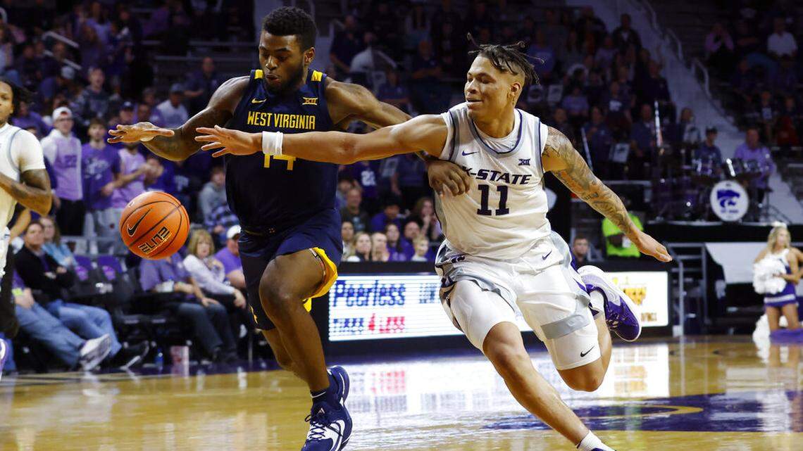 West Virginia guard Seth Wilson (14) and Kansas State forward Keyontae Johnson (11) chase down a loose ball during the second half of an NCAA college basketball game, Saturday, Dec. 31, 2022, in Manhattan, Kan.