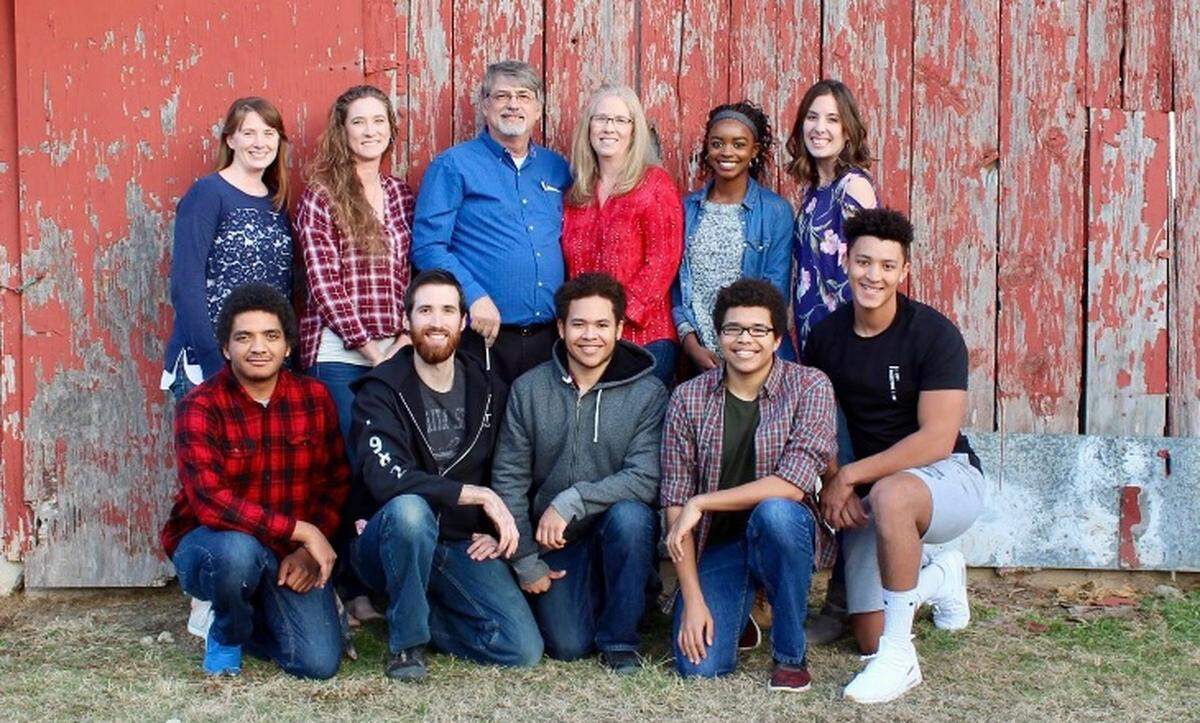 All 11 members of the Cook family pose for a picture outside their farmhouse in Whitewater. Kimalee Cook, in the back row, second from right, is a standout basketball senior at Circle High this year.