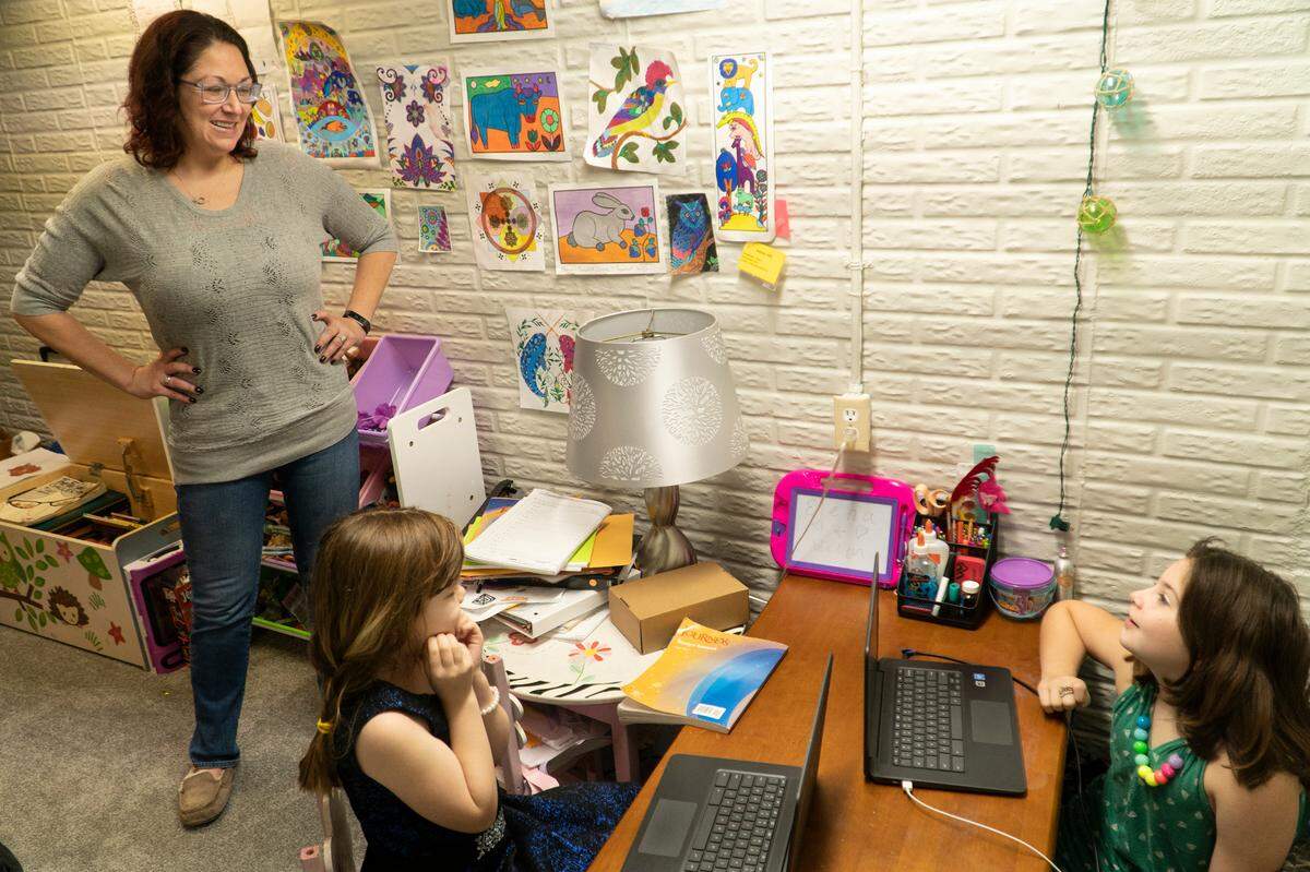 Lindsey Santellan converted the play room in her basement into a virtual learning center for her 7-year-old step-daughter Adelyn Hill, left and 10-year-old daughter Elena Santellan, right. Both attend Kensler Elementary School in Wichita. (December 4, 2020)