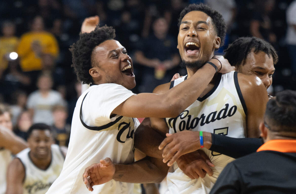 Team Colorado’s D’Shawn Schwartz is congratulated by teammates after he made a 3-pointer to hit the target score in a 65-61 against the AfterShocks in The Basketball Tournament on Monday night at Koch Arena. 