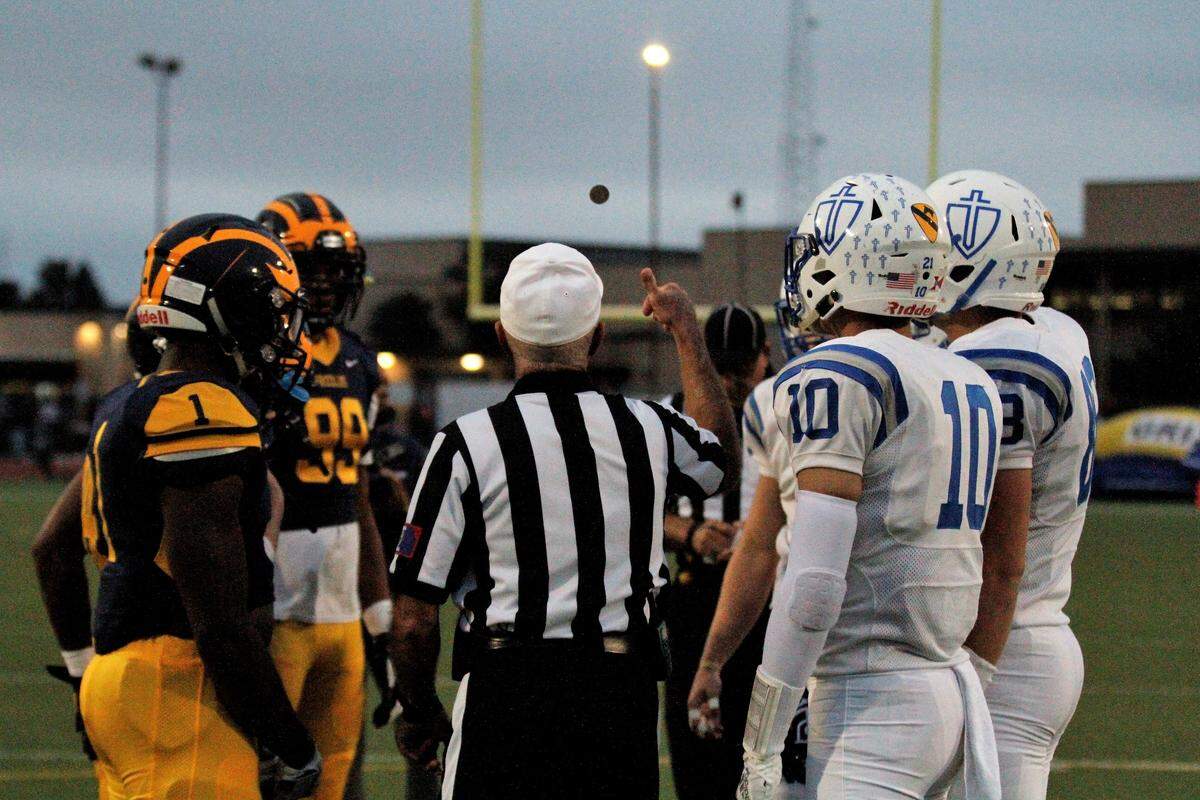 Wichita Northwest and Kapaun captains watch the referee flip the coin before the Grizzlies’ 55-26 win on Friday. (Sept. 28, 2018)