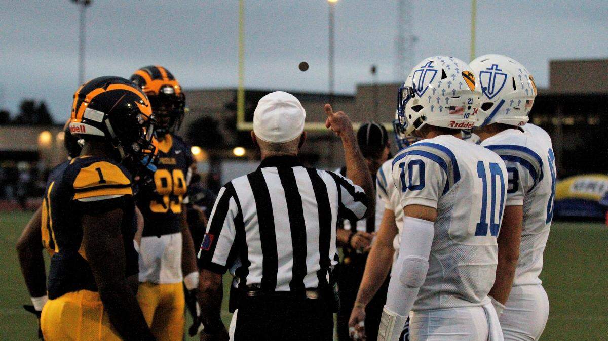 Wichita Northwest and Kapaun captains watch the referee flip the coin before the Grizzlies’ 55-26 win on Friday. (Sept. 28, 2018)