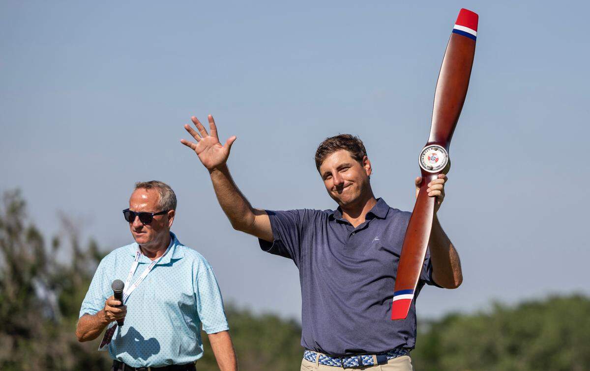 Taylor Dixon holds up the Wichita Open trophy after he won the tournament on Sunday. Dixon went into the clubhouse one shot behind, but Wichita native Sam Stevens bogeyed the final two holes to lose the tournament.