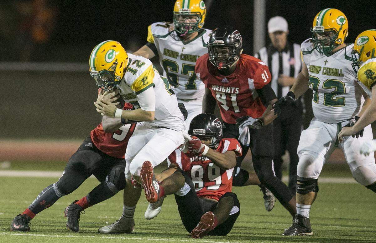 Bishop Carroll QB Braden Howell (12) grinds out some yards against Heights in the second quarter at Heights Friday. (Oct. 13, 2017)