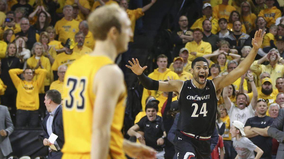 Cincinnati forward Kyle Washington celebrates as WSU's Conner Frankamp walks off the court after the Bearcats beat  Wichita State to claim the AAC title March 4 at Koch Arena.