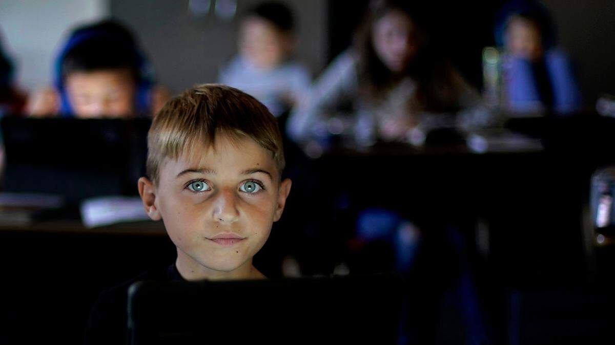 Conner Dowell uses a tablet to do a lesson in his third grade classroom at Highland Elementary School in Columbus, Kansas. The tiny, 900-student school system pivoted to remote learning briefly in March 2020 before going back in person that fall. While some U.S. students spent a year or more learning online, pandemic school in rural Kansas was as normal as it got. But the upheaval still took a toll.
