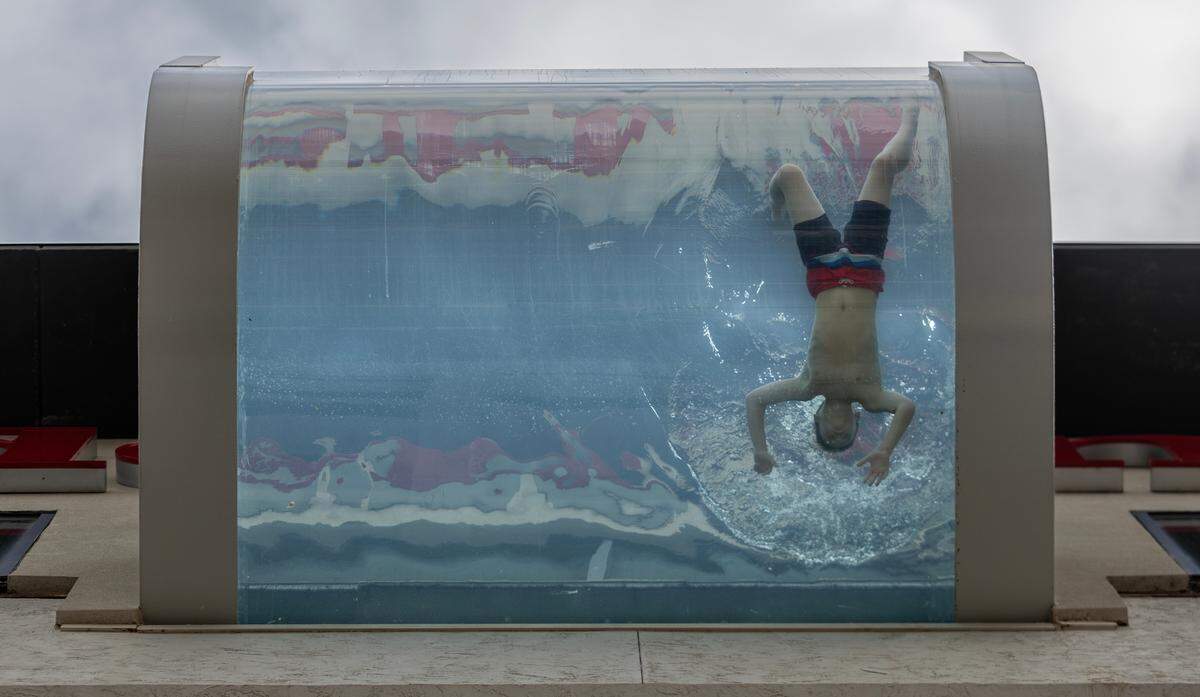 A boy swims in the Hilton Garden Inn’s rooftop pool, which has a glass-bottomed section that juts out over Douglas