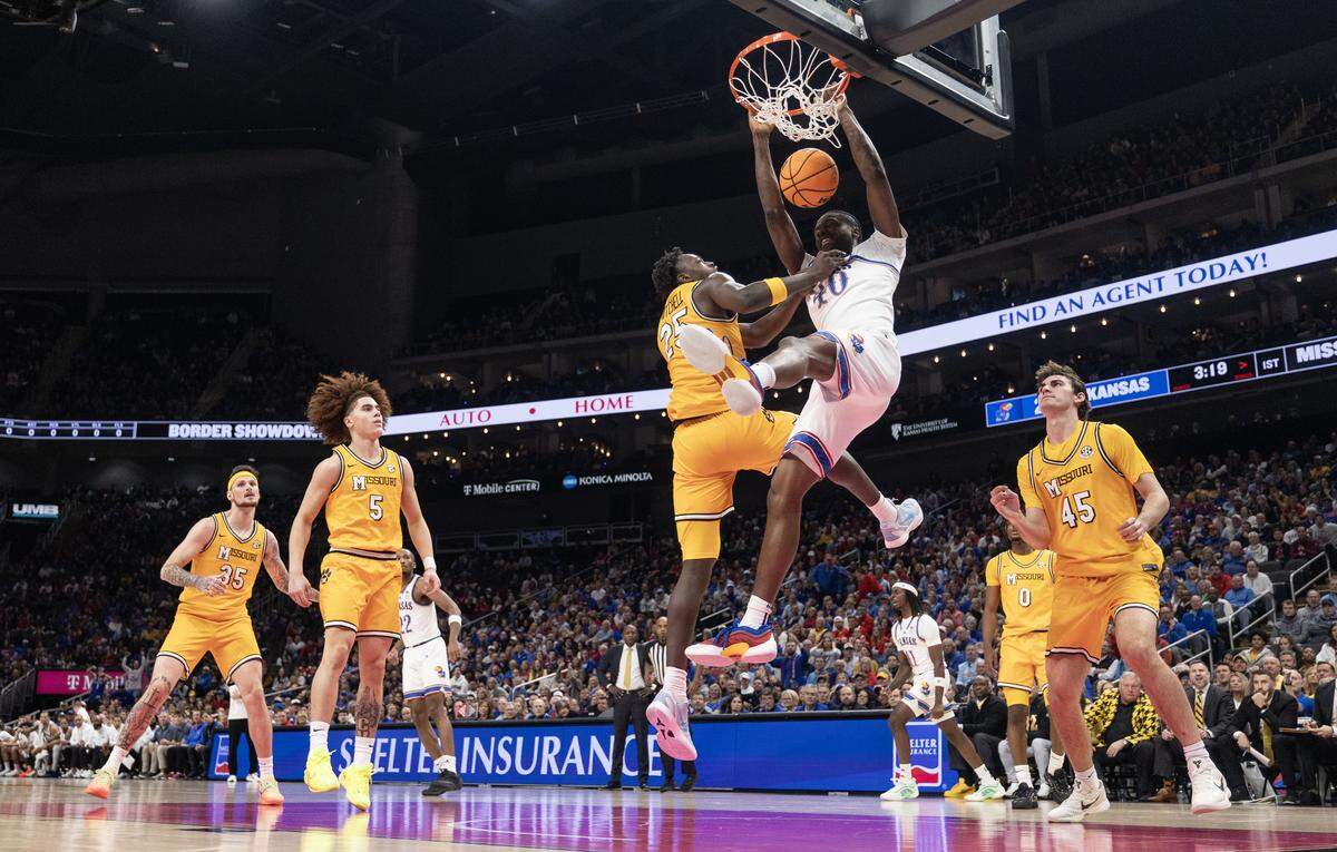 Kansas’ Flory Bidunga dunks over Missouri’s Mark Mitchell during the first half of their game at T-Mobile Center on Sunday, Dec. 7, 2025.