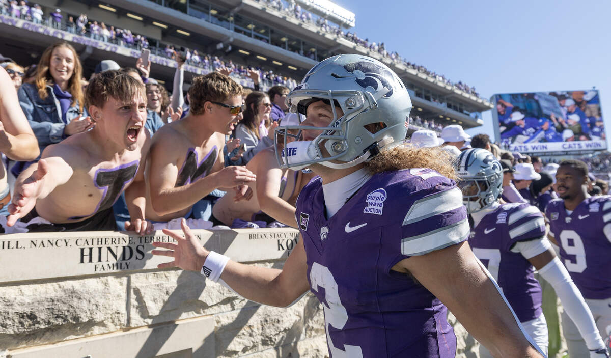 Kansas State quarterback Avery Johnson celebrates with fans after the Wildcats defeated Kansas for the 18th straight time in Manhattan on Saturday.