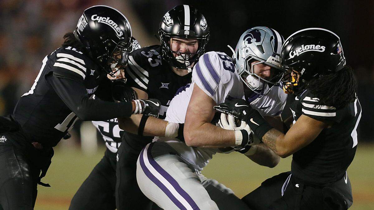 Kansas State Wildcats tight end Will Swanson (83) is tackled by Iowa State Cyclones defensive backs Darien Porter (10), Caden Kock (35) and Jamison Patton (2) during the third quarter at Jack Trice Stadium on Saturday, Nov. 30, 2024, in Ames, Iowa.