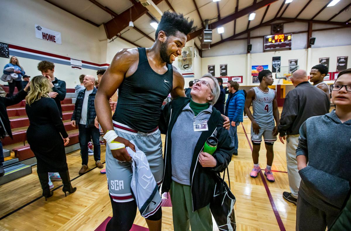 Sunrise Christian Academy’s Isaac Ondekane from Congo, center, jokes around with his ESL teacher Judith Richards after routing the Universal Academy Eagles from Irving, Tx., in Bel Air Thursday night.