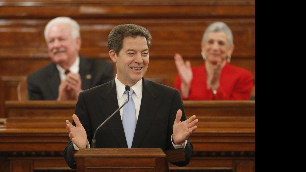 Kansas Gov. Sam Brownback addresses the Kansas House and Senate Tuesday night in Topeka during his State of the State address. Behind Brownback is Speaker of the House Ray Merrick (left) and Senate President Susan Wagle. (Jan. 15, 2013)