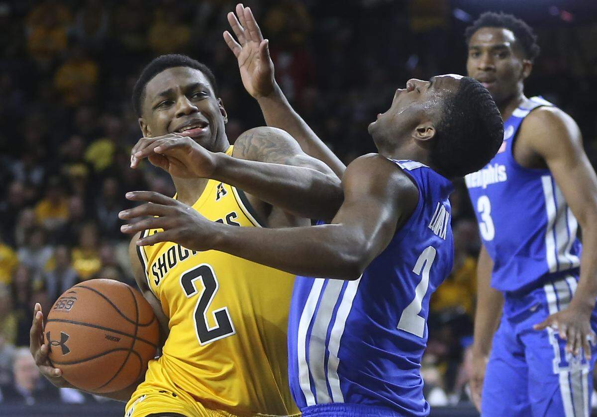Wichita State guard Jamarius Burton fouls Memphis guard Alex Lomax during the second half of their game at Koch Arena on Saturday. 