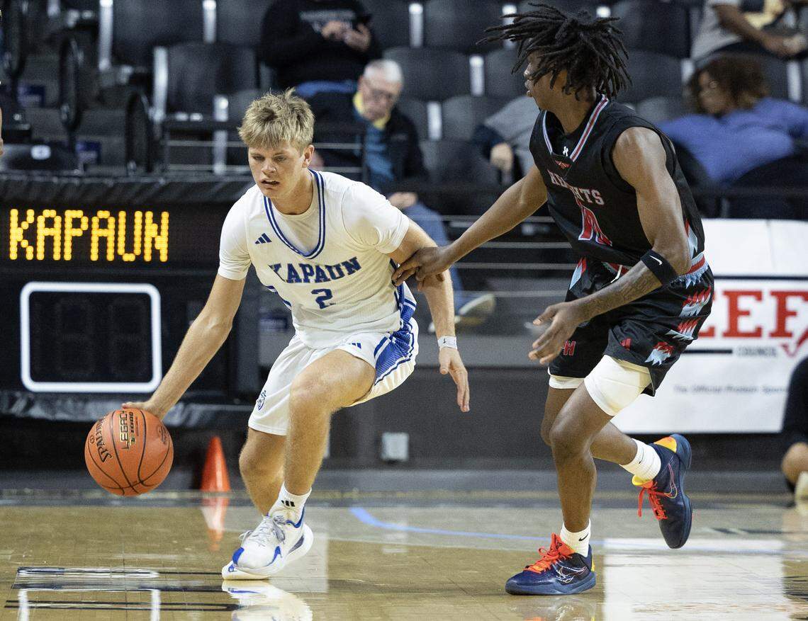Kapauan’s Jude Porter brings the ball up the floor against a Shawnee Heights defender on Tuesday at the quarterfinals of the 6A basketball tournament at Koch Arena.
