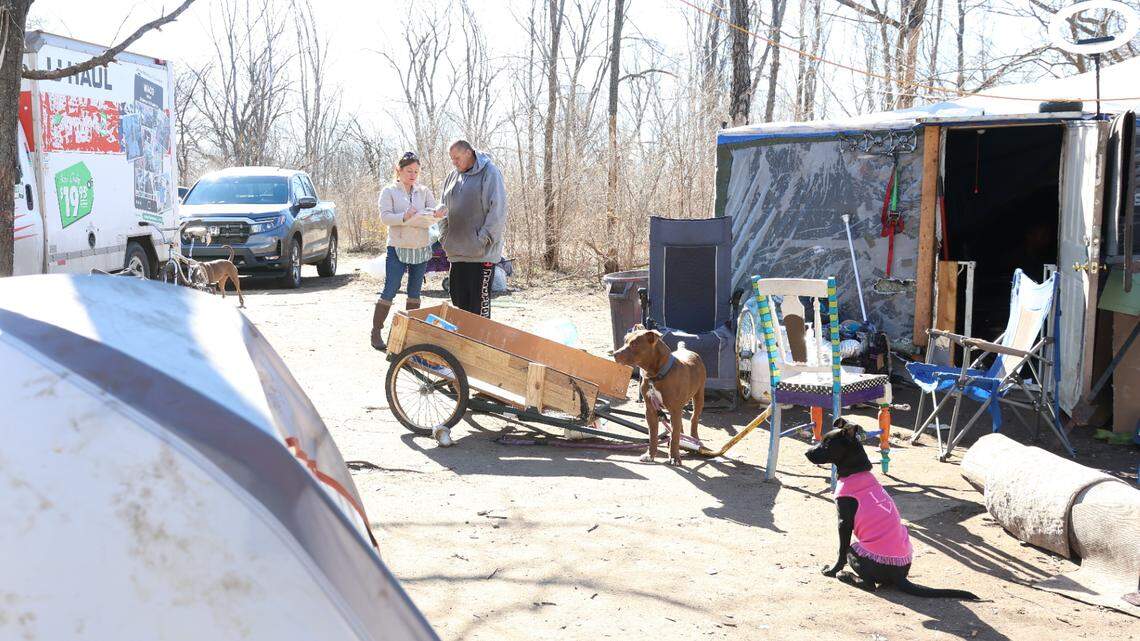 Jillian Castaneda, a housing crisis navigator with the United Way of the Plains, speaks to an unhoused person at an encampment. Castaneda is part of a team that helps get chronically homeless people into housing — a program that was recently affected by federal funding cuts.