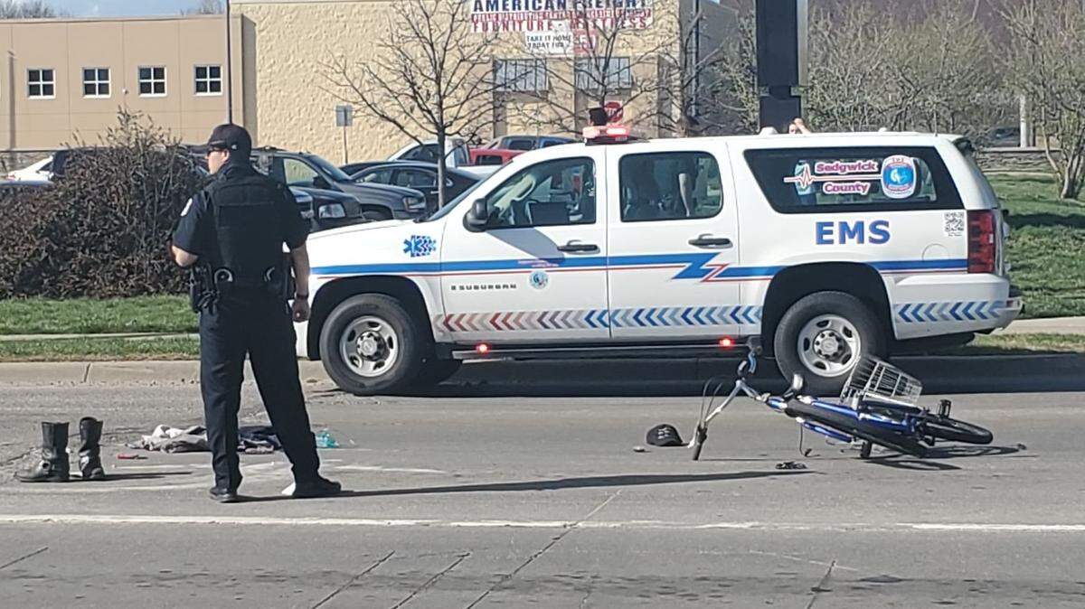 A Wichita police officer stands near where a man was hit by a vehicle and then shot Friday afternoon at 13th and Oliver. The man died and a woman was arrested.