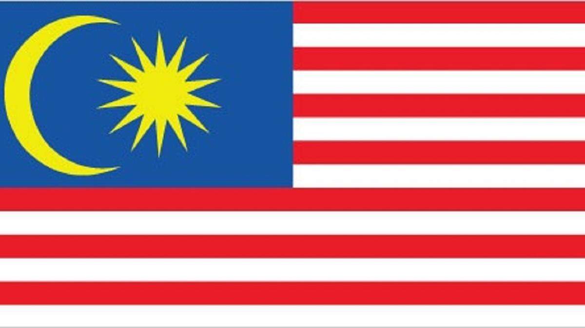 The Malaysian flag has alternating red and white stripes and a blue rectangle in the upper left corner, much like the American flag. Unlike the American flag, it has a crescent moon and a 14-point star on the blue rectangle.