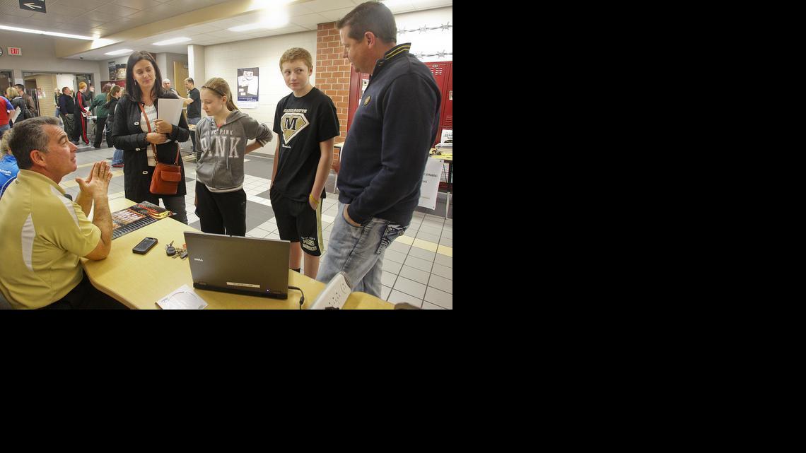 Kelly and Melanie Flynn and their children, Maize Middle Schoolers Peyton and Talon, second from right, talk with history teacher and coach Mike Domnick, left, during Maize South’s Open House “showcase” night. (Nov. 7, 2013) 


