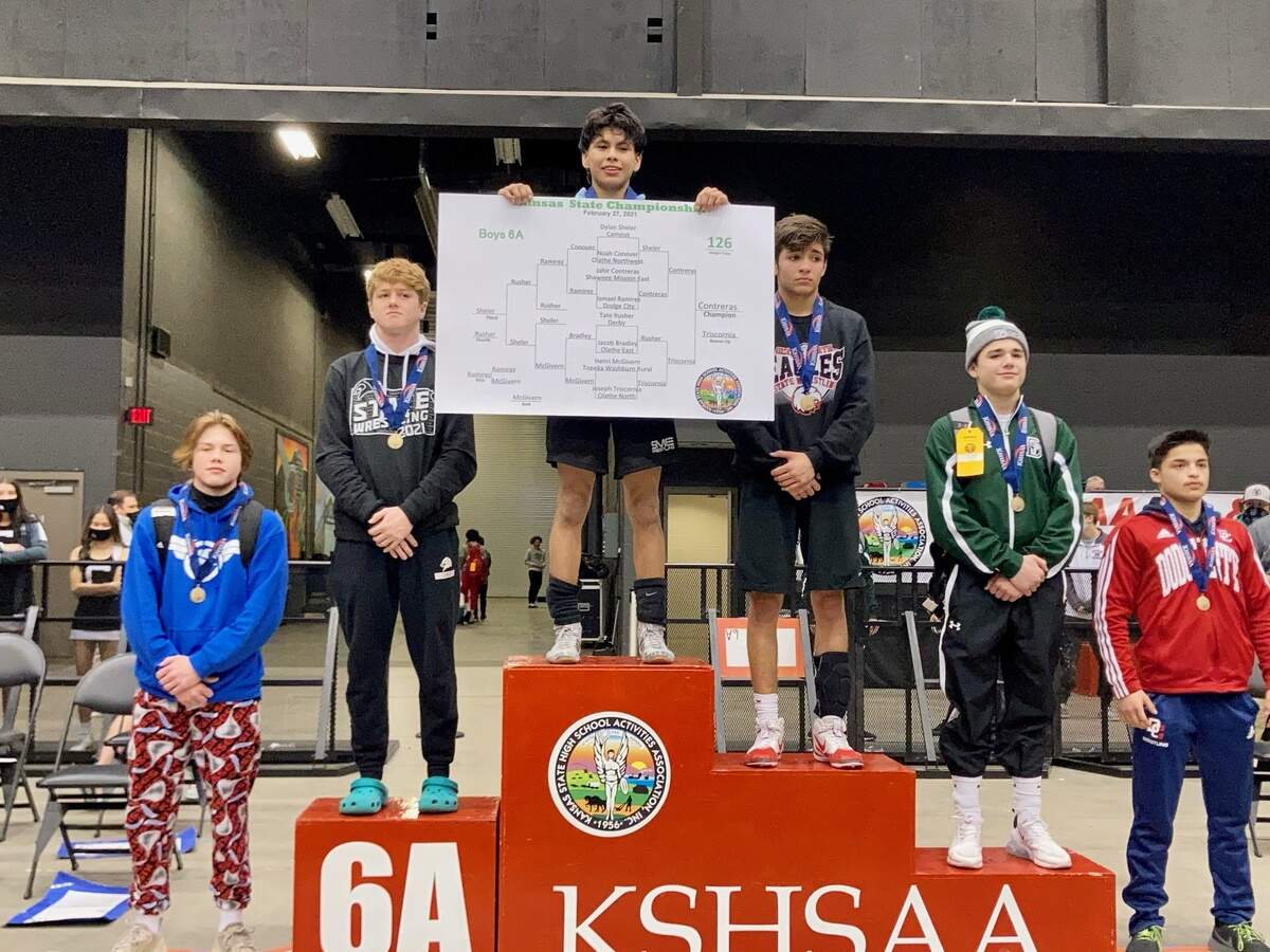 SM East Jahir Contreras stands atop the podium after winning the Kansas Class 6A 126-pound state wrestling championship.