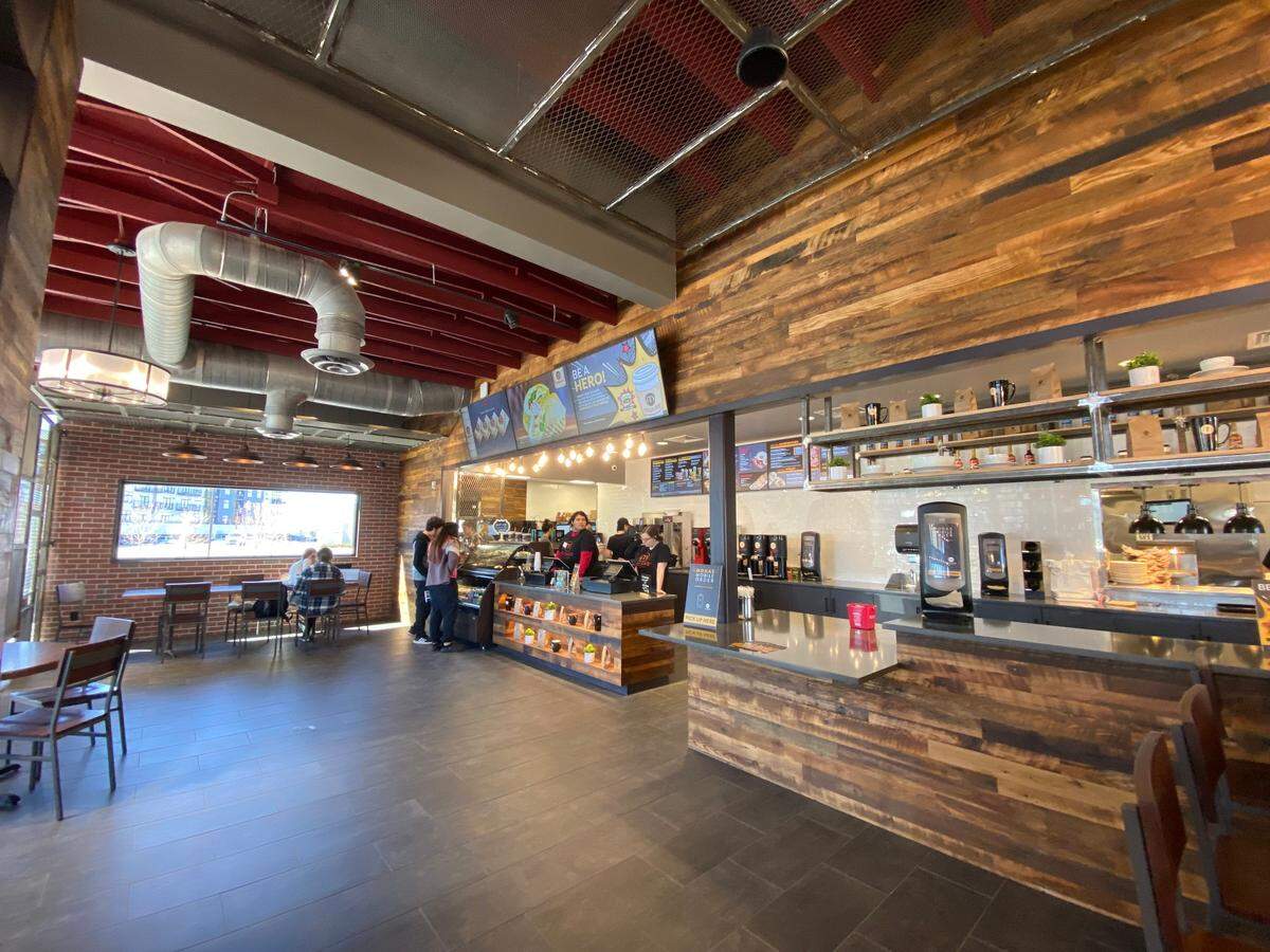 Customers order drinks and food at the counter at Mokas Cafe, which has both indoor and outdoor seating.