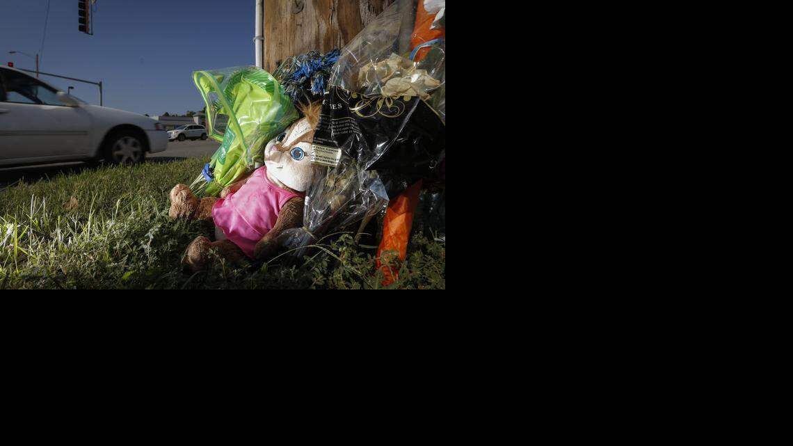 Flowers, stuffed animals and other mementos make up a roadside memorial at Maple and Tracy streets on Aug. 2. Three people died in a car wreck a week earlier.

