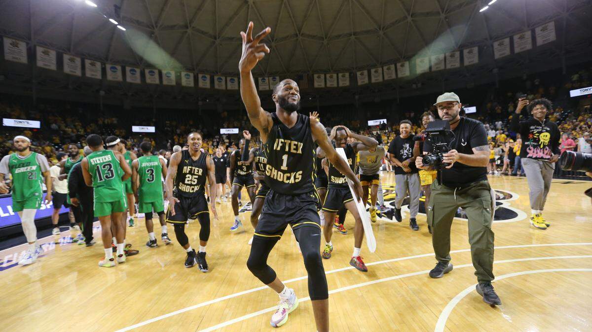 Markis McDuffie dances to place the AfterShocks banner on the tournament bracket wall after they won their second straight regional championship in The Basketball Tournament.