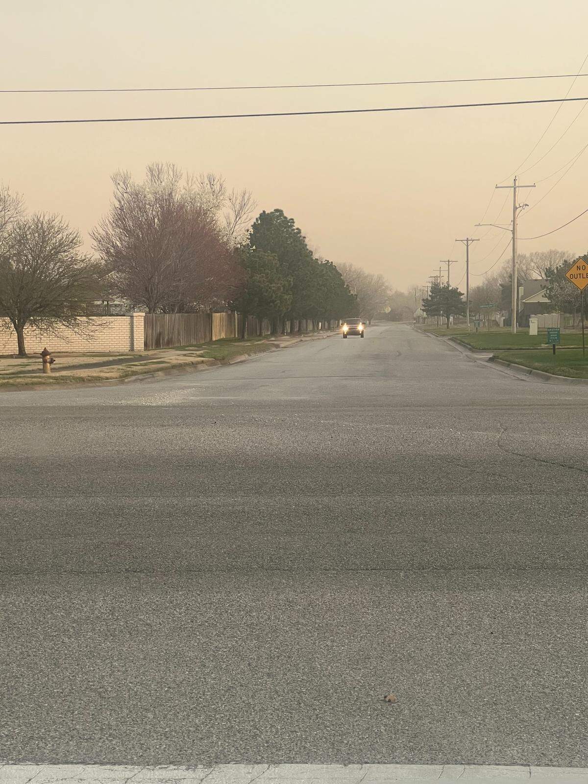 Allergist and immunologist Van Strickland shot this photo of a vehicle driving with its lights on during the day on Sunday due to all the dust in the air from high winds.