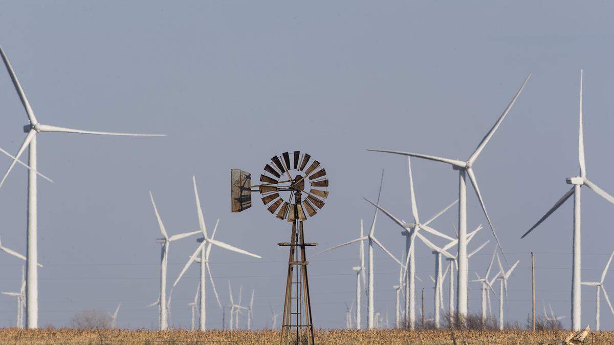 Wind turbines dwarf a traditional windmill at the Flat Ridge 2 wind farm that spans Kingman, Harper and Barber counties. Sedgwick County has placed a moratorium on wind and solar development for six months.