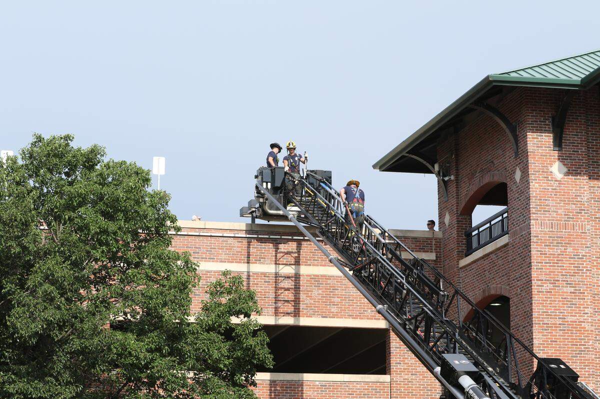 Wichita firefighters were on scene being hoisted towards the top floor of the the Old Town parking garage after two people were found dead inside a car.