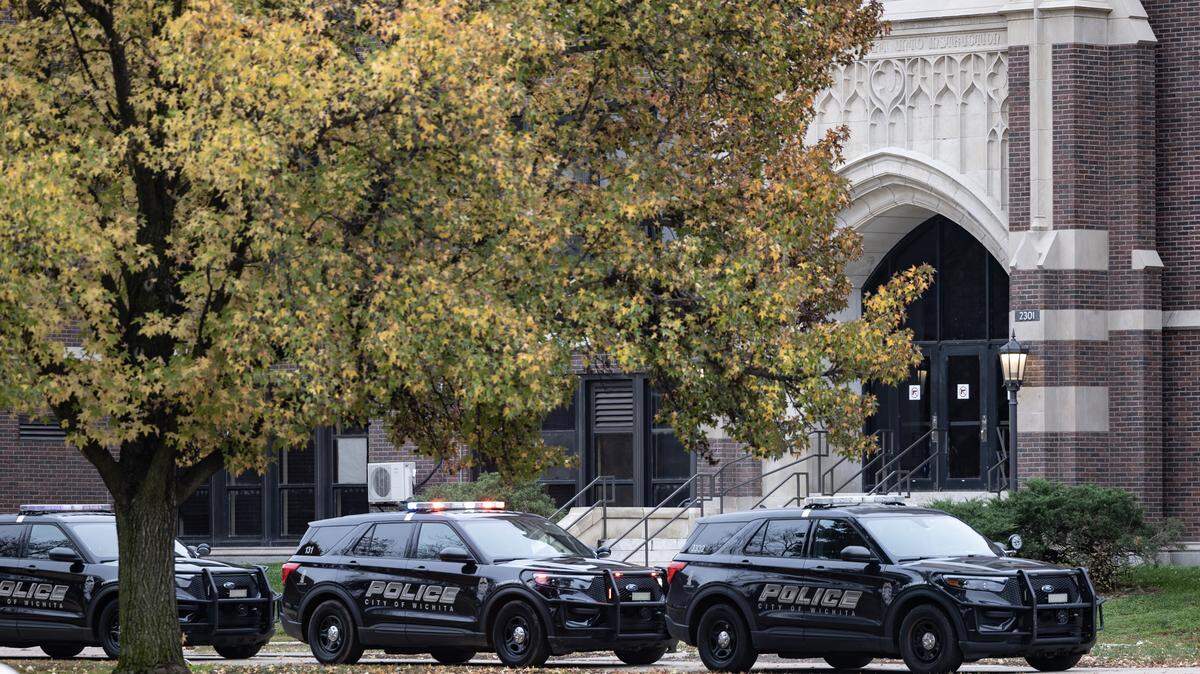 Police cars were parked outside of East High on Friday afternoon. A staff member died at the school on Friday, but the school didn’t disclose the circumstances.
