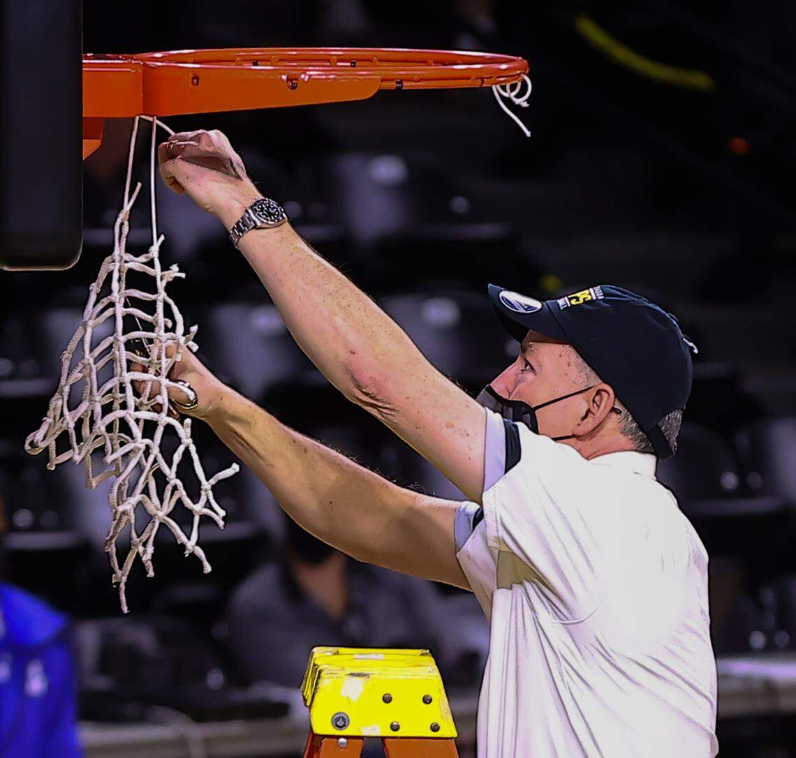 Wichita State assistant coach Billy Kennedy cuts down a piece of the net at Koch Arena following WSU clinching the American Athletic Conference regular season championship this past season.