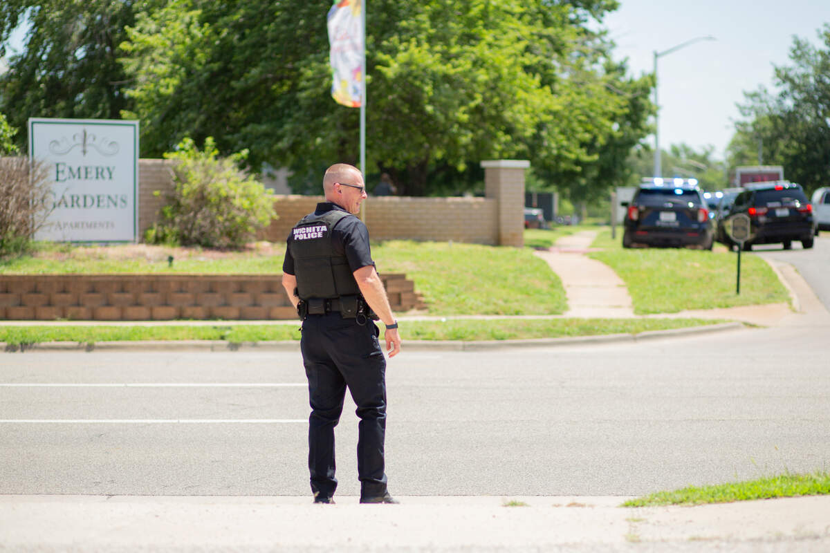 Wichita police Lt. Brandon Lenzi prepares to cross the street to the scene of a shooting at Emery Garden Apartments on Monday, June 24. Lenzi said a shooting occurred shortly after 11 a.m. and the victim is expected to survive.