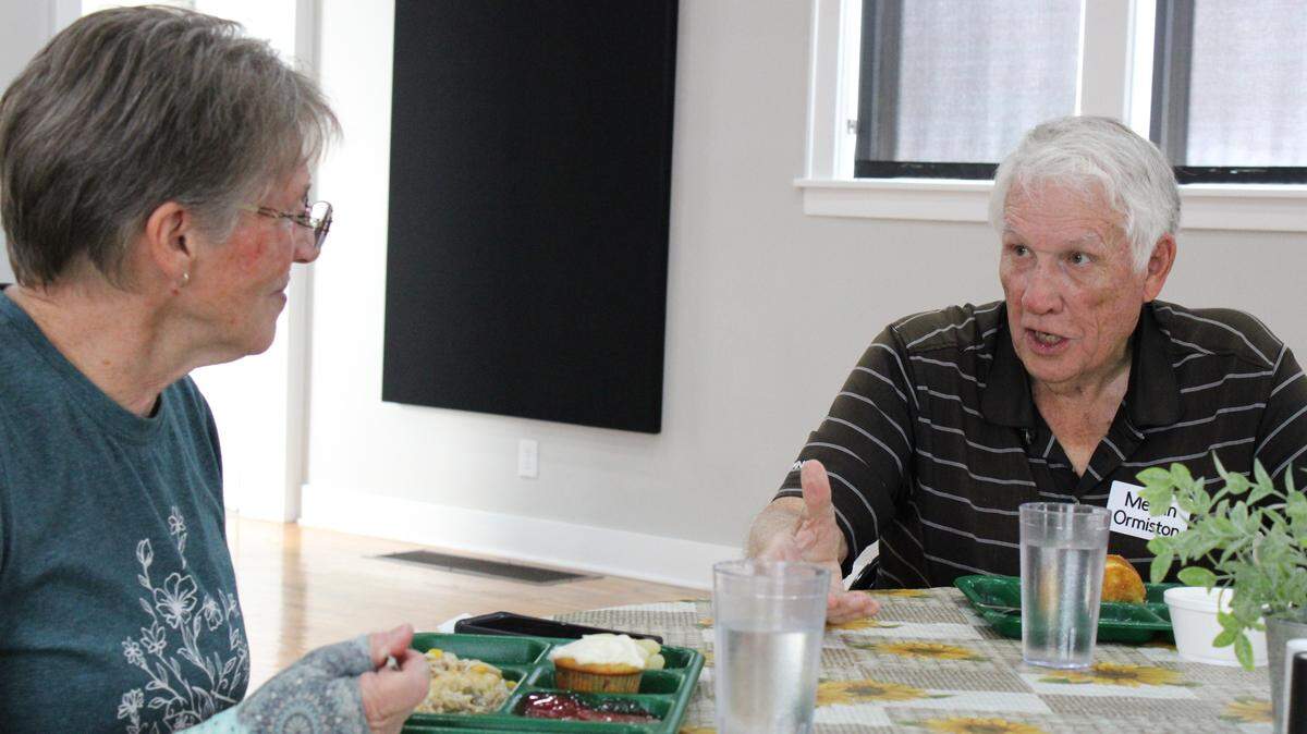 Becky King, left, and Melvin Ormiston chat over lunch at a table in the Goddard Senior Center. The two are both retired education professionals.