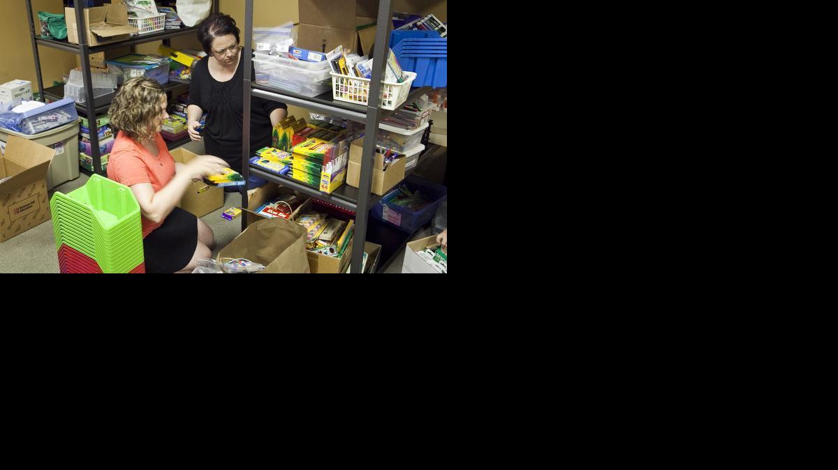 Rachel Johnson, left, and Andrea Anglin help arrange back-to-school supplies available at no cost to teachers at GracePoint Church. 

