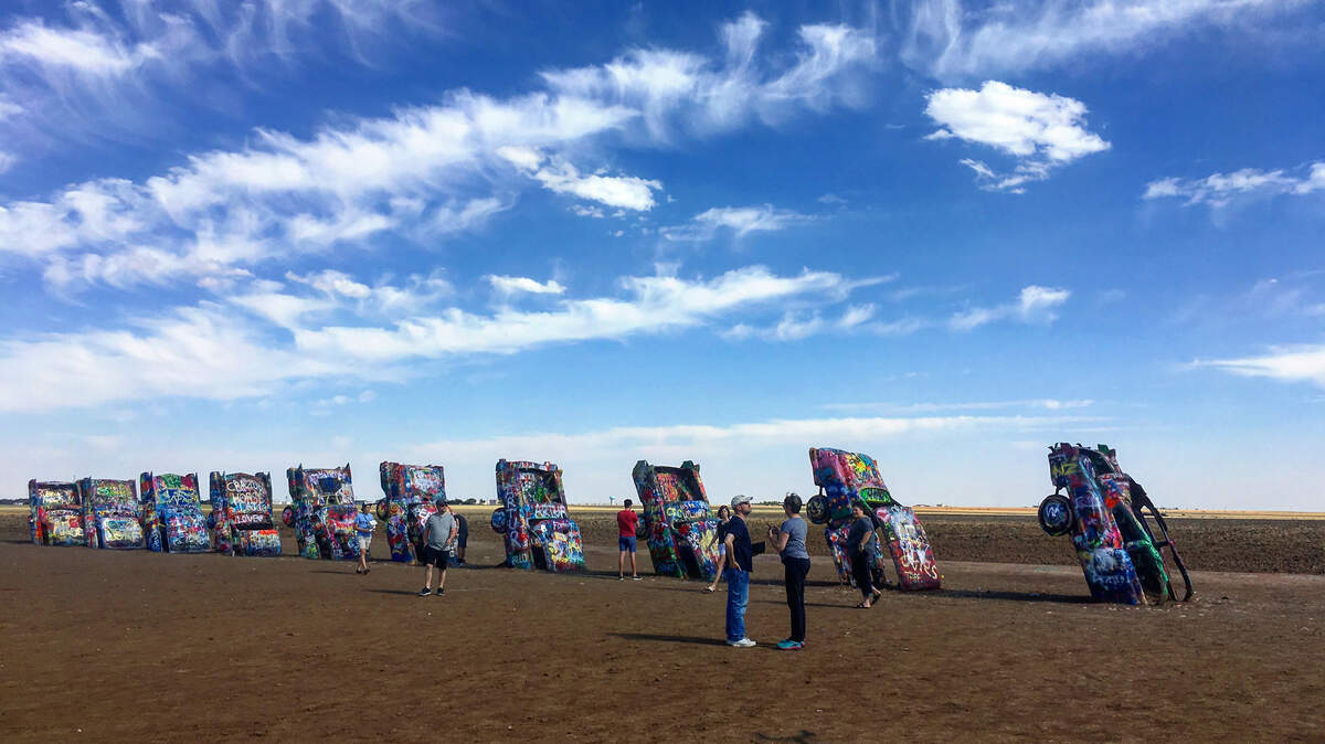Cadillac Ranch features 10 Cadillacs buried nose first in a wheat field alongside Interstate 40 on the west edge of Amarillo. Visitors spray paint the installation.