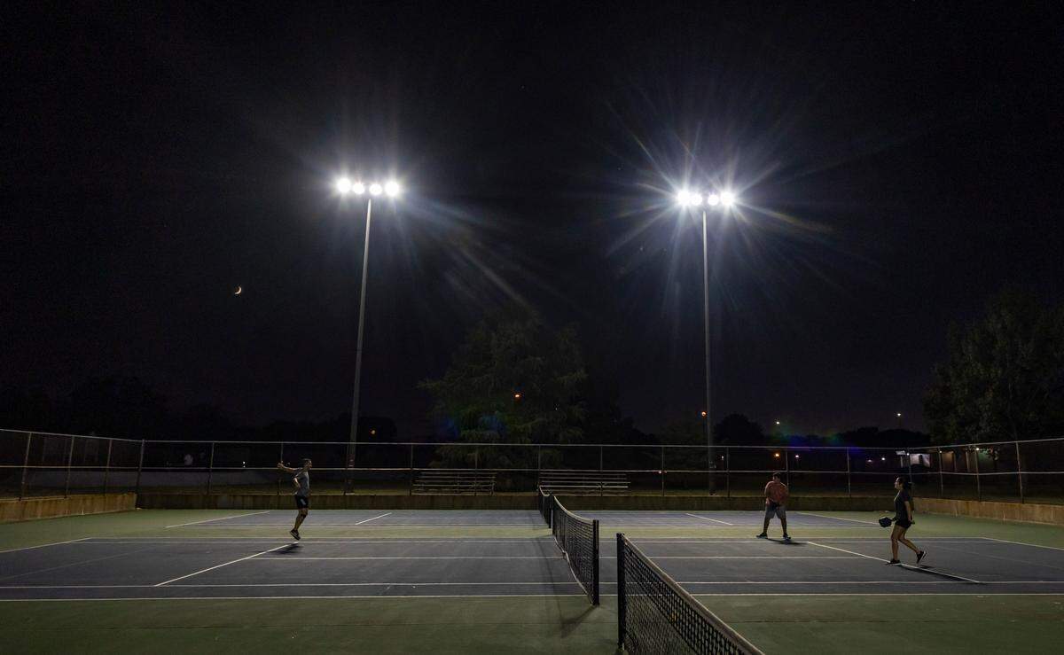 Pickle ball players play on a tennis court at Edgemoor Park recently.
