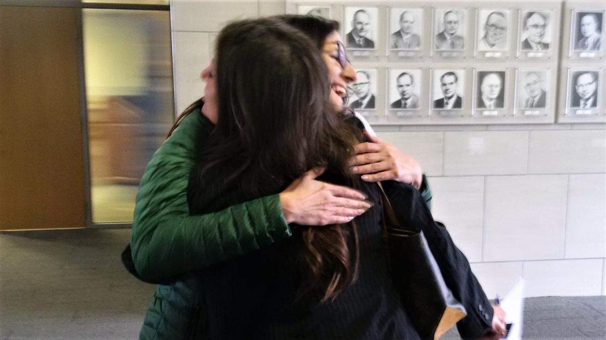 Jamie Schmaltz (facing camera) hugs Amanda Meyers in a City Hall hallway after the City Council approved funding for the Wichita Family Crisis Center to buy a hotel and turn it into a domestic violence shelter.