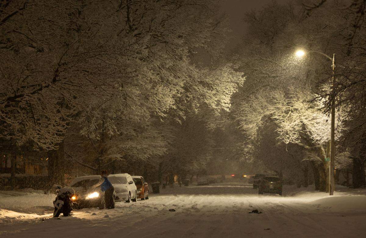 A motorist clears their car in Delano during a heavy snowfall on Thursday night.