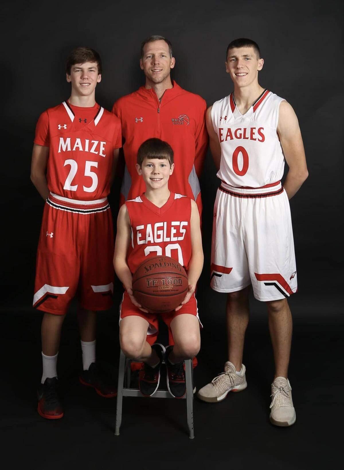 Maize boys basketball coach Chris Grill joined by his three sons: Caleb (right), Kyle (left) and Alec (middle).