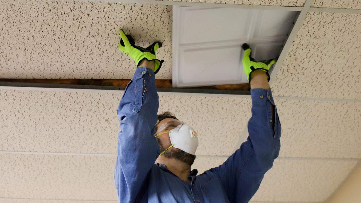 Barry Dicker, president of Decent Energy and principal investigator, installs thermal energy storage ceiling tiles at the Wellington City Hall.