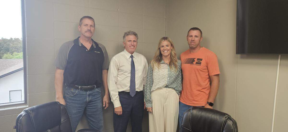 Todd Bailey, second from left, helped Ron Fehr, left, sell his west-side PostNet business to Stephanie and Brandt Wise.