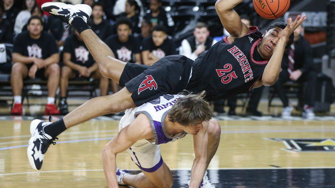 Heights’ Qyree Holtf falls over Blue Valley Northwest’s Michael Pauley during the second quarter of the 6A Championship game at Koch Arena on Saturday.