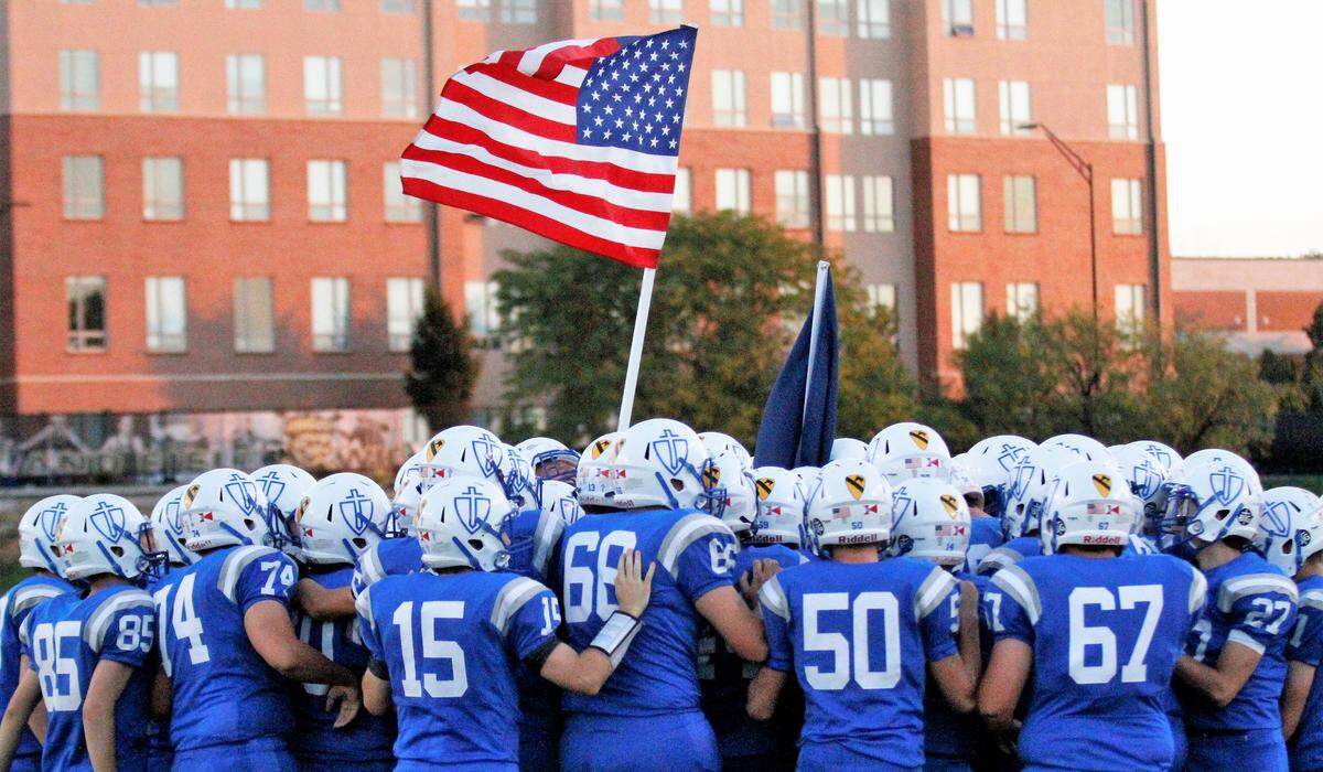 Kapaun gathers waving the American flag before its game against Bishop Carroll on Friday. (Oct. 5, 2018)