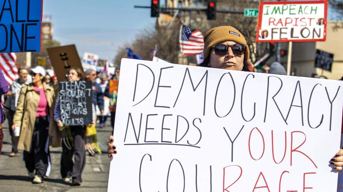 A woman advocates for democracy at Saturday's’ “No Kings” protest in Wichita.