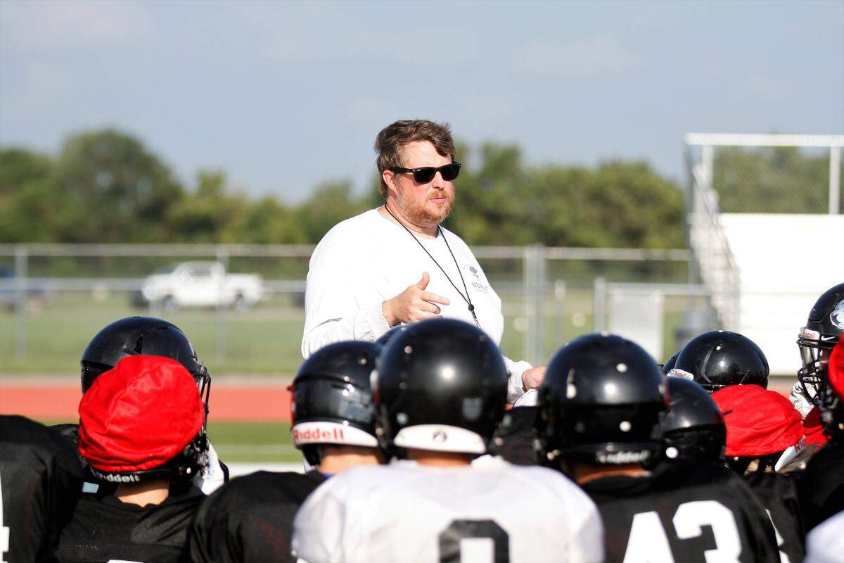 Eisenhower football coach Marc Marinelli talks with his team after a fall practice.